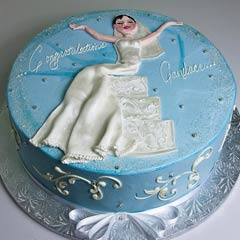 Round blue bridal shower cake decorate with white swirls and a bride wearing a white bridal gown cake design