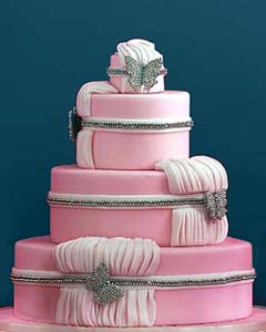 Very feminine, three tier round pink fondant wedding cake with draped pink gathered fondant. Decorated with diamontee butterfly brooches
