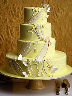 Very arty, four tier, yellow retro wedding cake, decorated with swirls and pattens from the 1940's