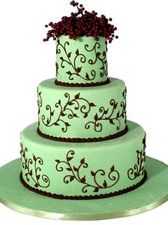 Round three tier brown and green wedding cake decorated with intricate brown scroll work