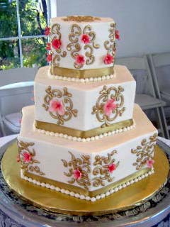 Three tier white, gold and pink retro hexagonal shaped wedding cake
