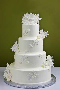  Simple four tier, winter white Christmas snowflake wedding cake is decorated with large snow white handcrafted and edible cascading snowflakes
