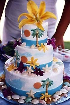Three tier Hawaii Maui theme wedding cake garnished with tropical pine trees and seashells
