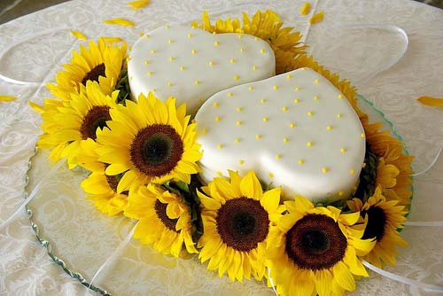 Sunflower heart shaped wedding cakes decorated with yellow sunflowers
