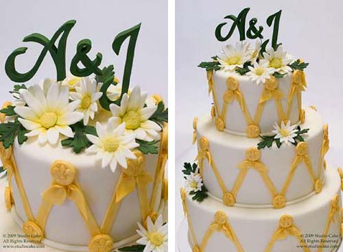 Three tier white and yellow designer wedding cake decorated with white and yellow fondant daisies