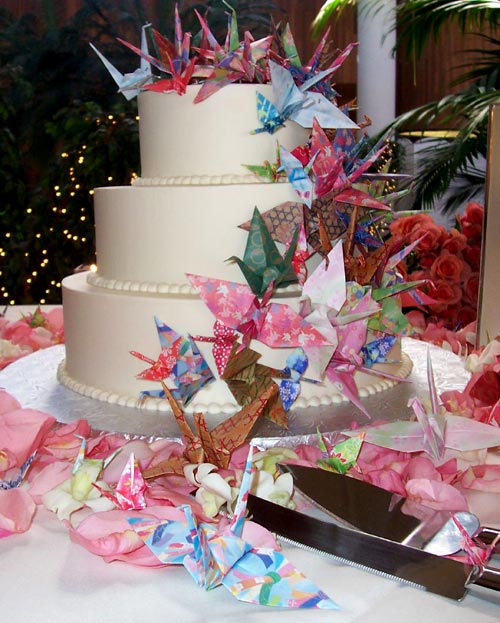 Unique three tier white Japanese style wedding cake decorated with colourful cascading japanese paper origami cranes