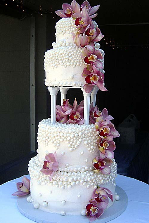 Huge gorgeous four tier round shaped wedding cake garnished with pink Cymbidium Orchids