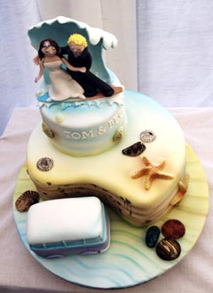 two tier beach theme wedding cake with caricatures of the bride and groom