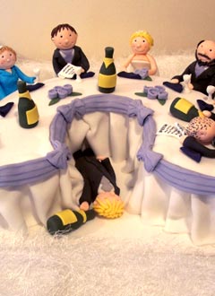 Humorous novelty wedding cake with caricatures of the bride and groom and the bridal party