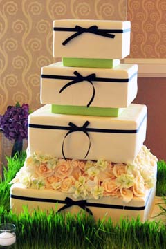 Square four tier green and white 1940's retro style wedding cake decorated with black ribbon and bow