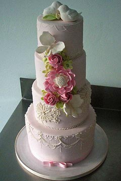 four tier pastel pink wedding cake, decorated with ornate and intricate patterns, handmade sugar and fondant flowers