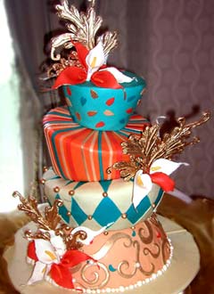 Harlequin, stripe and swirl wedding cake decorated with blue, orange, peach and white fondant patterns
